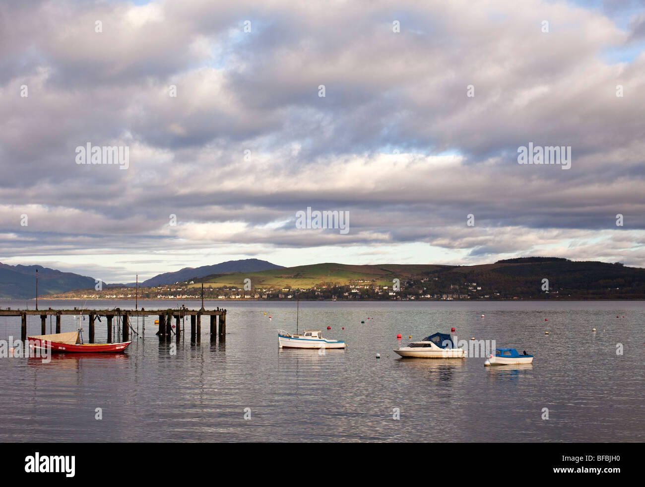 Vista dalla baia di Cardwell in Gourock attraverso il argyle colline con barche locali e in disuso Admiralty Pier in primo piano Foto Stock