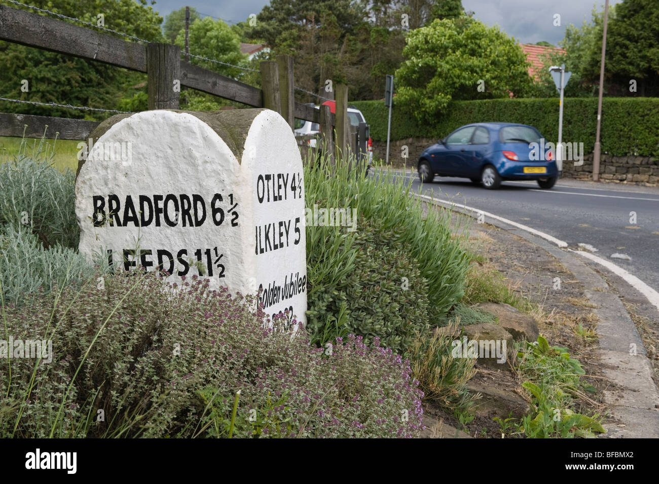 Primo piano sulla pietra miliare del Giubileo (tappa di un villaggio rurale, città locali, distanze, numero di miglia, chilometraggio) - Hawksworth by Leeds, West Yorkshire, Inghilterra, Regno Unito. Foto Stock
