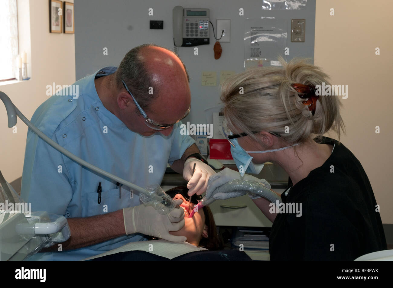 Dentista e assistente dare ad un paziente in una moderna chirurgia dentale di un regolare checkup Foto Stock