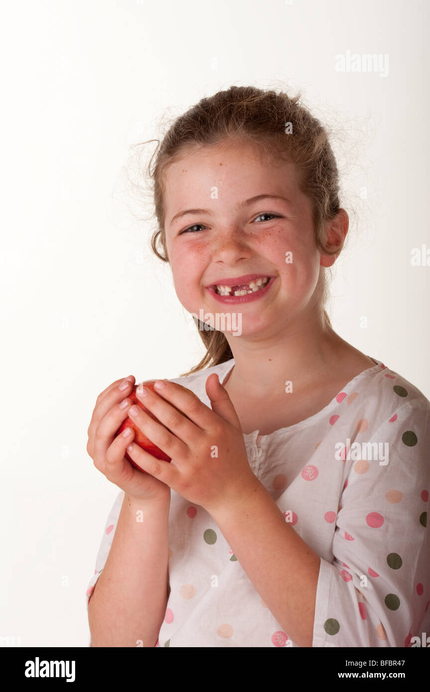 Bambina (7 anni) anteriore mancanti due denti e azienda apple Foto stock -  Alamy