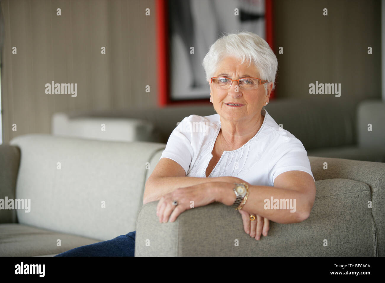 Signora anziana rilassante sul divano Foto Stock