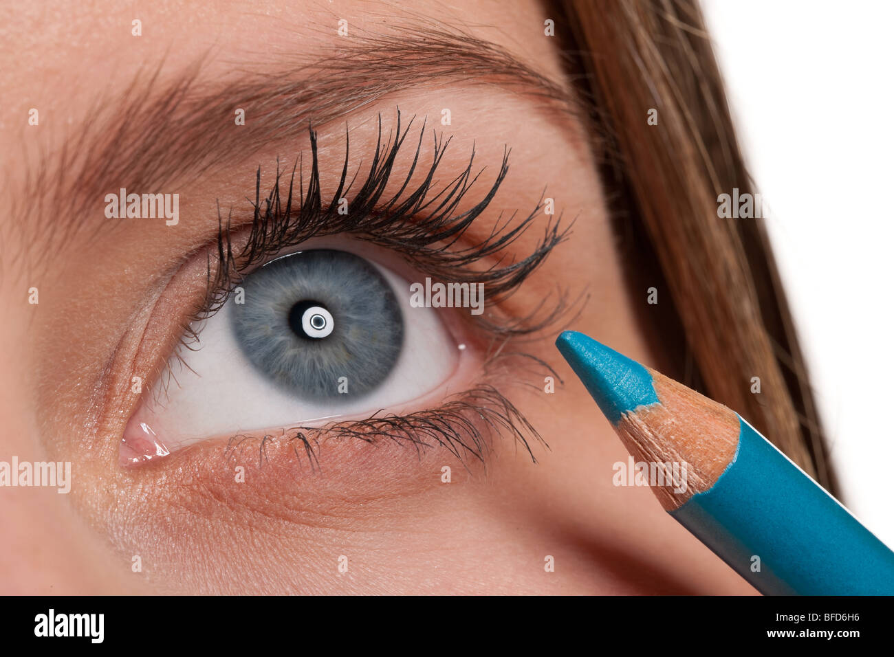 Close-up di blue eye, donna applicazione di make up blu matita, lenti macro Foto Stock