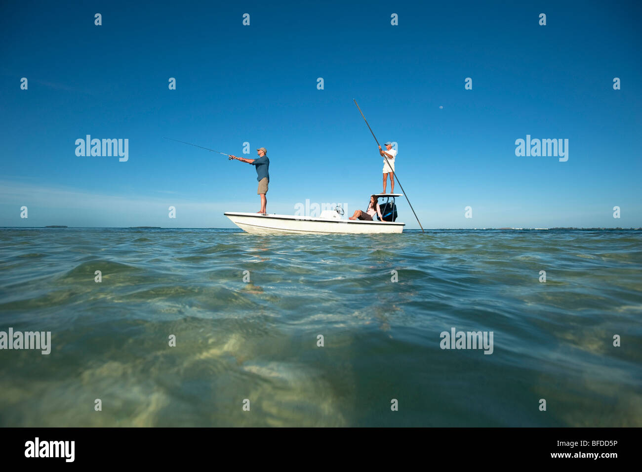 Un paio di pesce come un uomo piloti una piccola barca in Florida. Foto Stock
