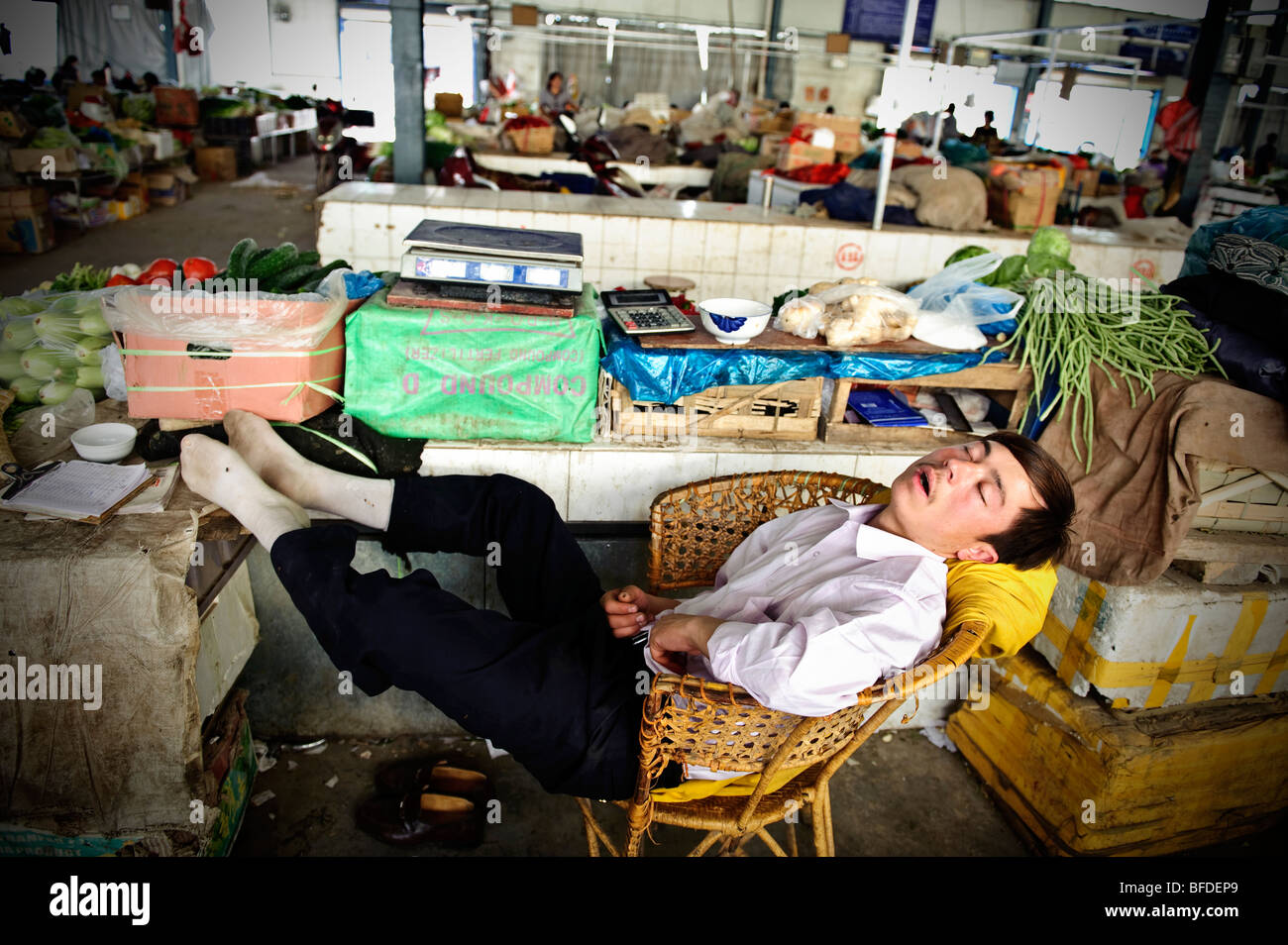 Un proprietario di un negozio di dormire in uno dei bazar di Kashgar, Xinjiang, Cina. Foto Stock
