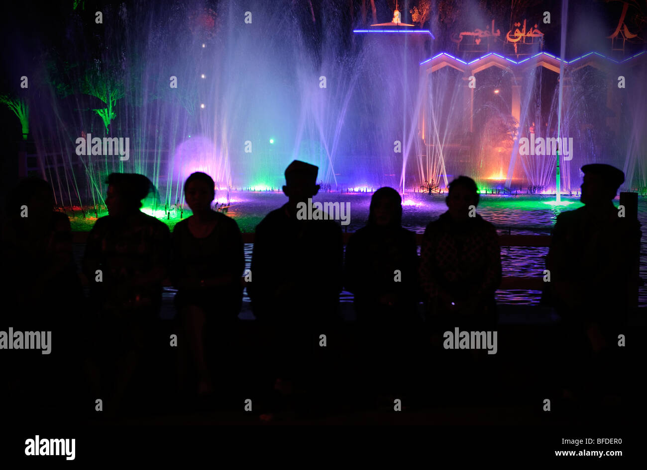 Uiguri seduto accanto a una delle fontane a Kashgar la piazza principale della città. Foto Stock