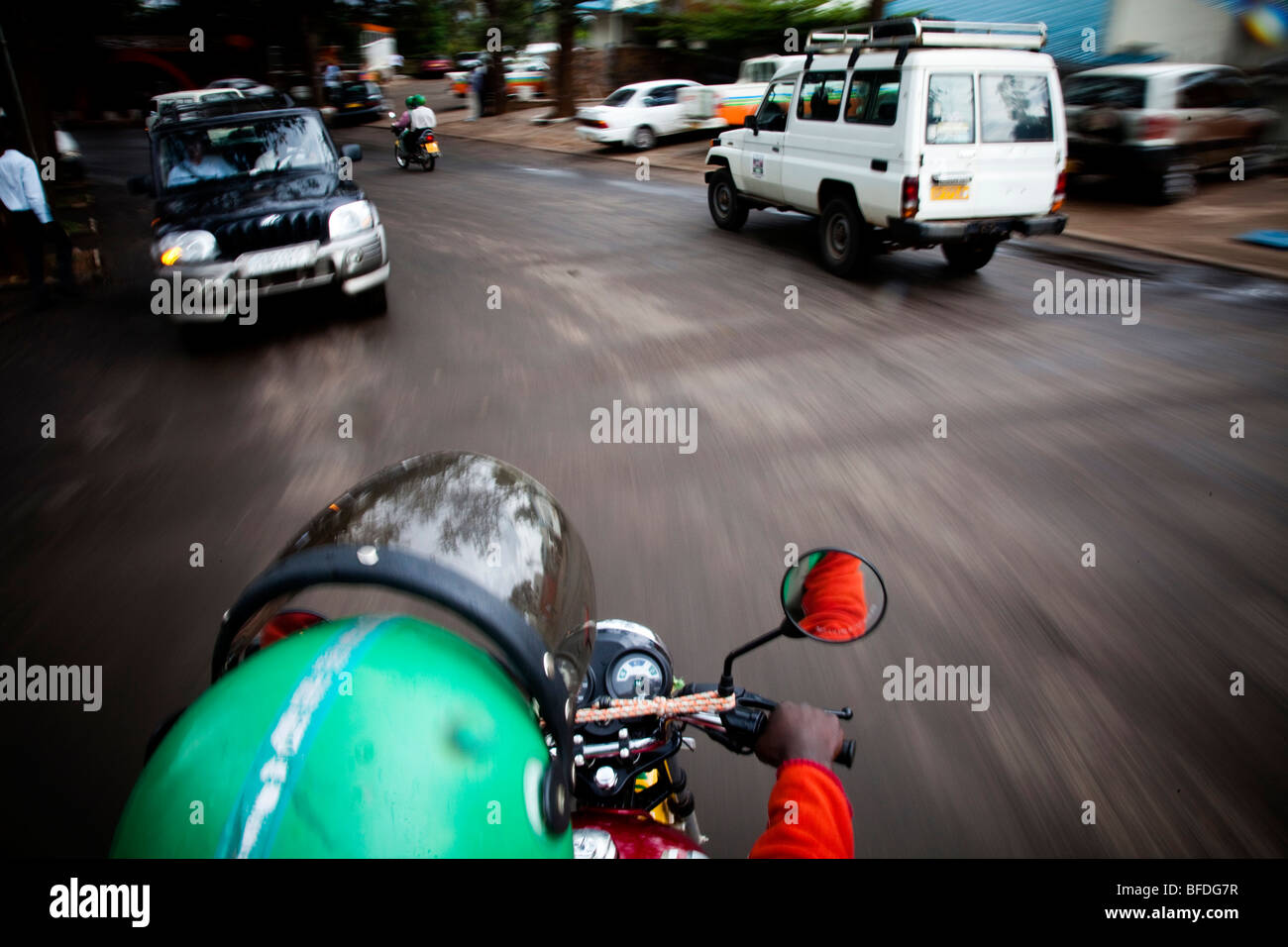 Una vista dal sedile posteriore di un motociclo in movimento attraverso le strade di Kigali, Ruanda. Foto Stock