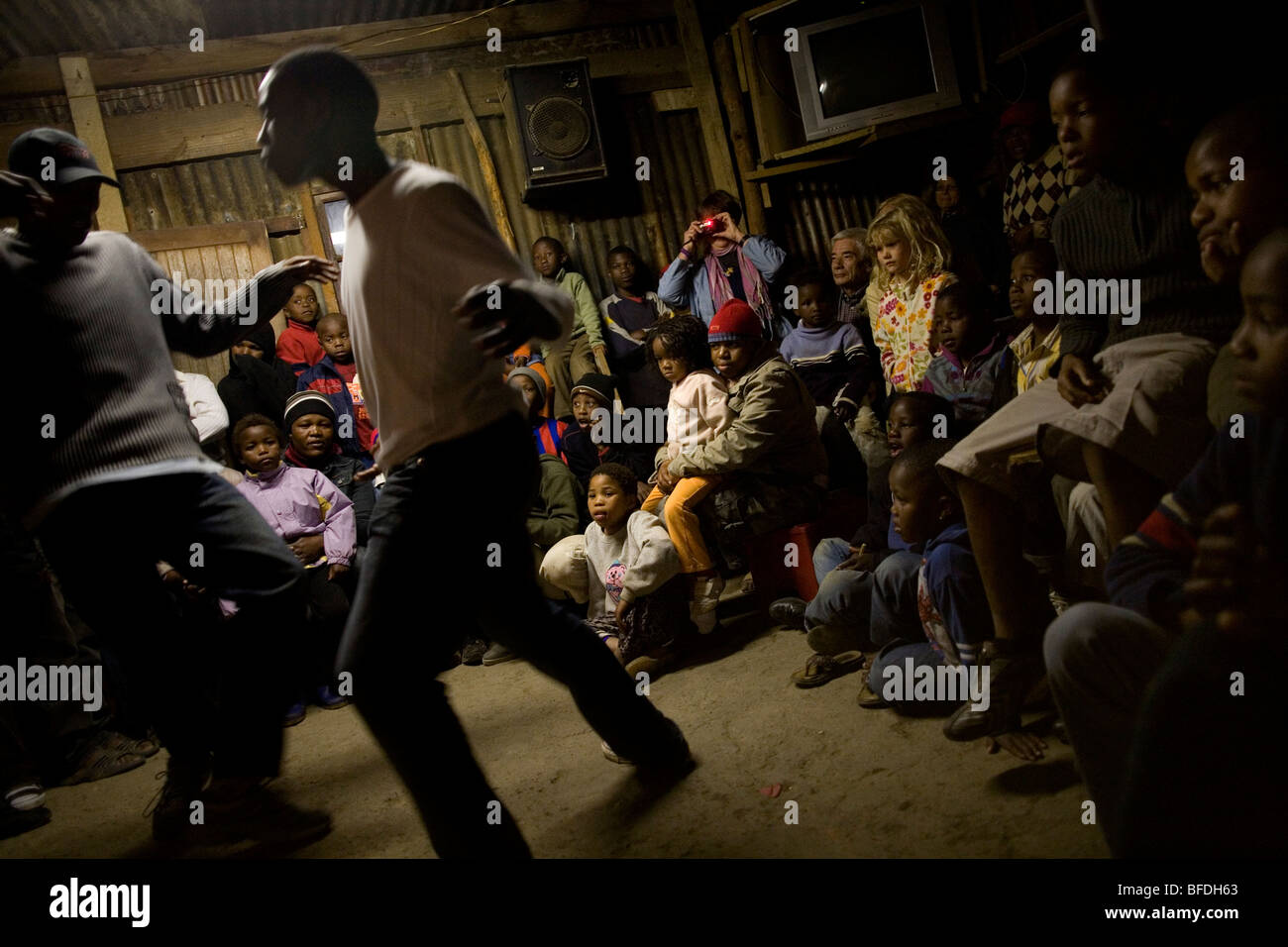 I turisti guardare balli locali mentre su un township tour di Imizamo Yethu Township, Hout Bay, Sud Africa. Foto Stock