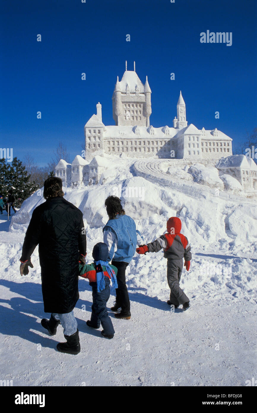 Famiglia a piedi dalla scultura di neve a Winterlude Festival, Jacques Cartier Park, Hull (Gatineau), Quebec, Canada. Foto Stock