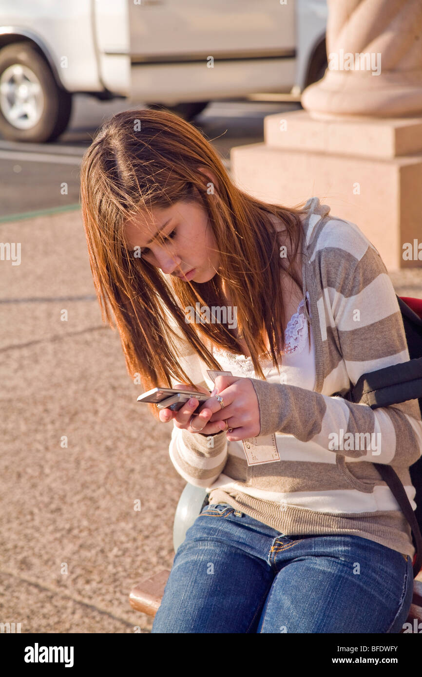 13-14 anni di età anni teen girl texting utilizzando iPhone cellulare. California caucasica. Signor Foto Stock