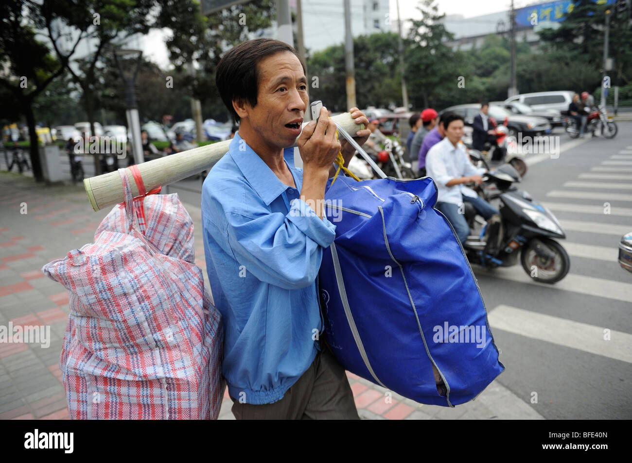 Un lavoratore migrante è perduto e interroga il modo con il suo telefono cellulare in Cina a Shanghai. 16-ott-2009 Foto Stock