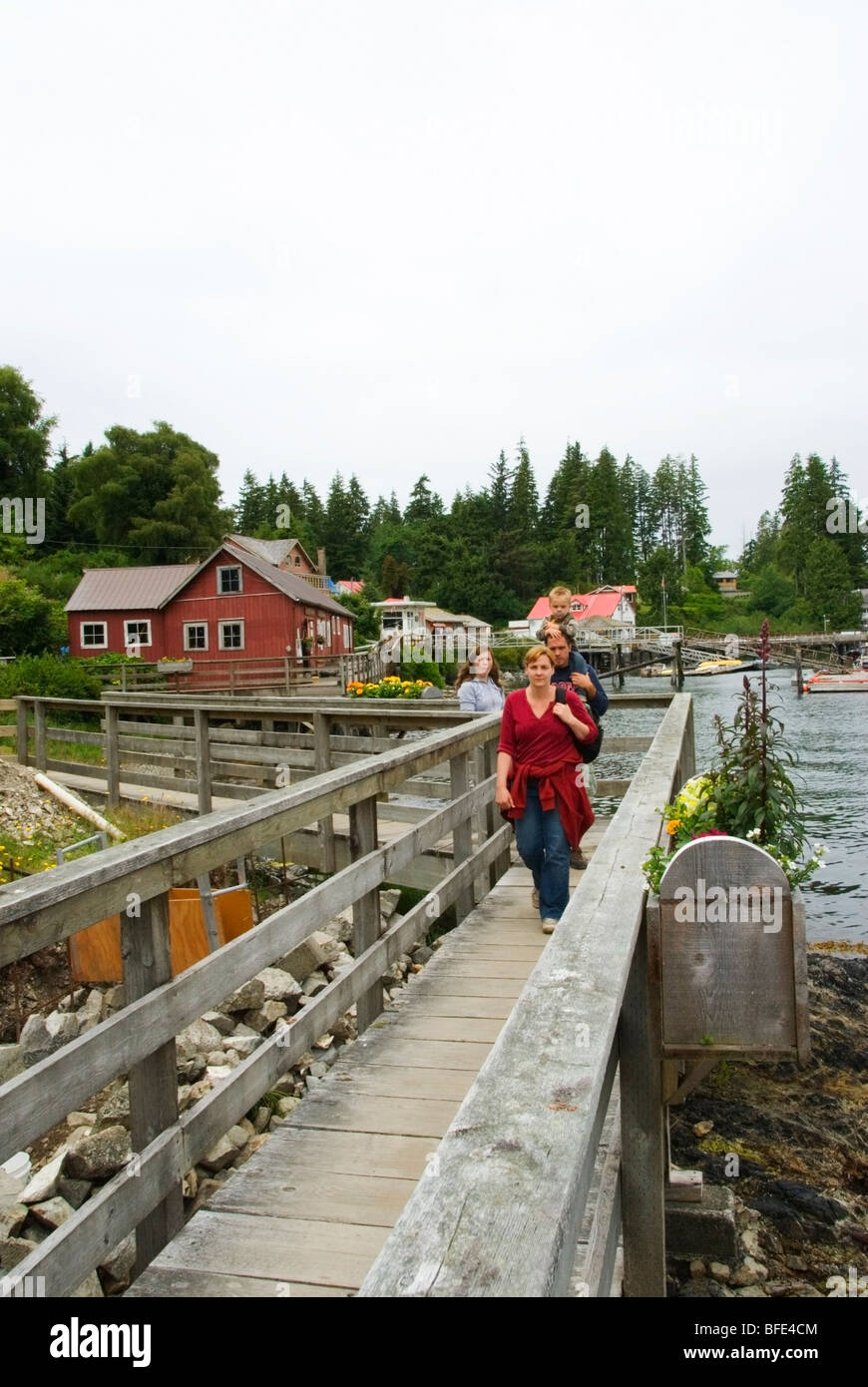 Una famiglia sul mare lungomare nel villaggio costiero di Bamfield, Isola di Vancouver, British Columbia, Canada Foto Stock