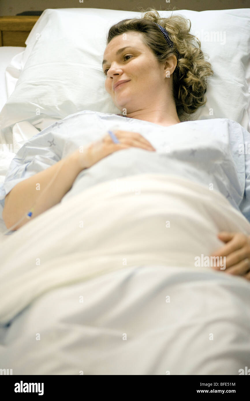 36 anni di donna che sta per partorire giacente in letto di ospedale, Chateauguay, Quebec, Canada Foto Stock