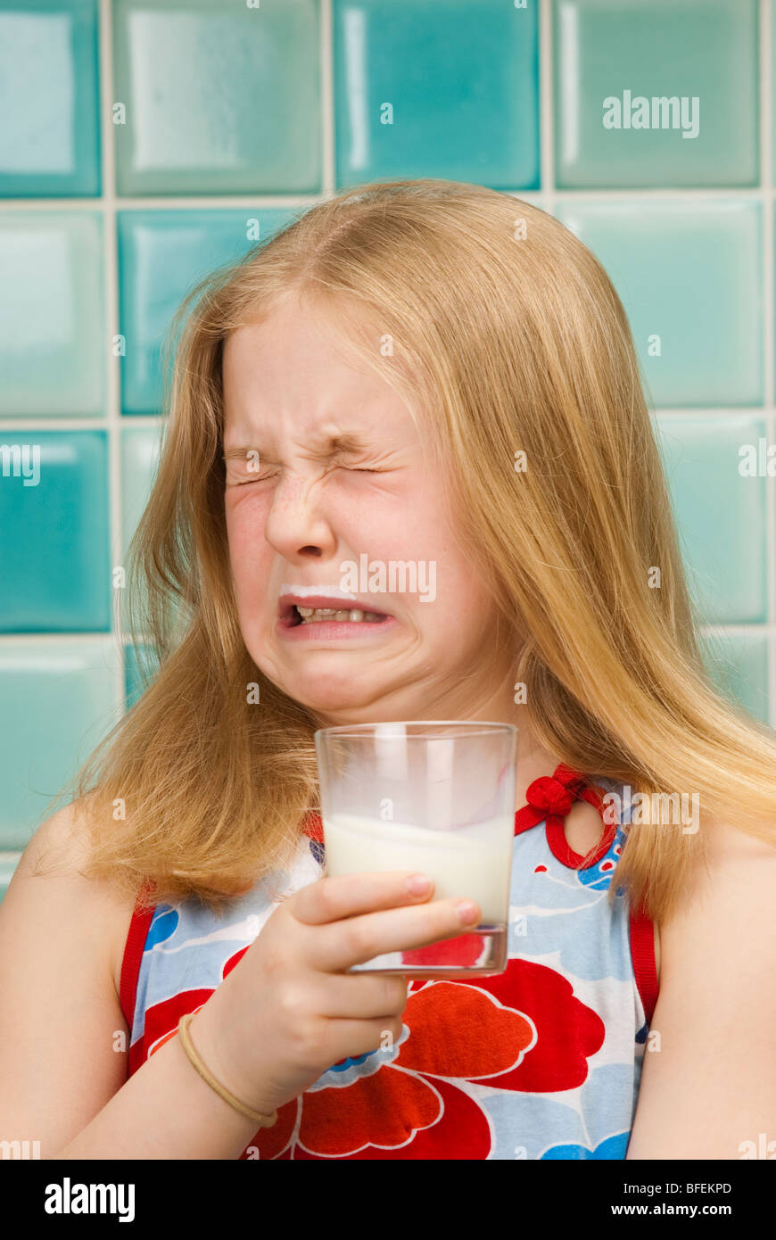 Giovane ragazza non gradisce un bicchiere di latte Foto Stock