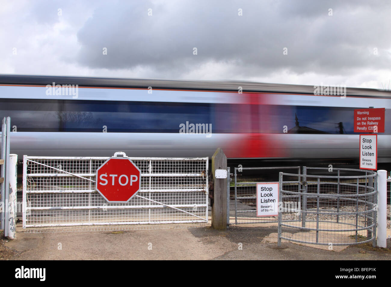 Treno passa presidiati gated passaggio a livello, Worcestershire, England Regno Unito Foto Stock