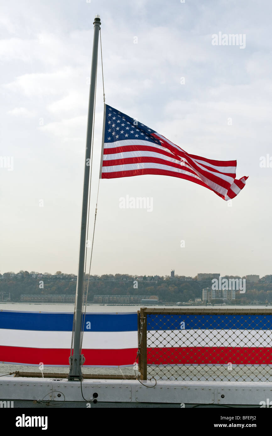 Noi sventola a metà il montante sulla poppa della nave USS New York per onorare le vittime del World Trade Center crollo Foto Stock