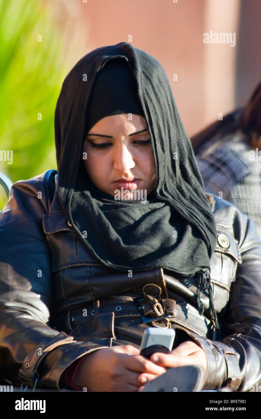 Giovane donna musulmana usando un cellulare a Marrakech in Marocco Foto Stock