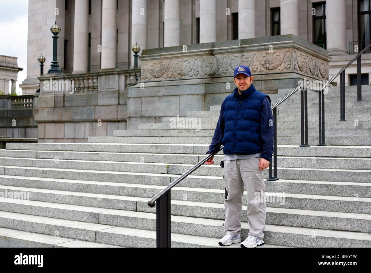 Uomo in piedi sui gradini del Washington State Capitol in Olympia, Washington. Foto Stock