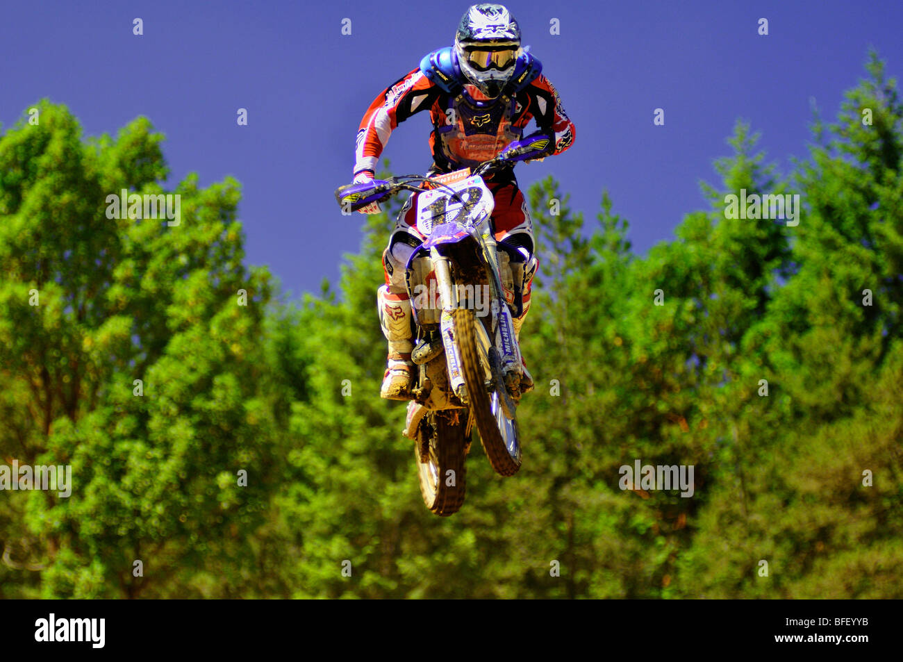 Motocross racer #12 airborne durante Pro evento nazionale a lande desolate di Nanaimo, BC Foto Stock