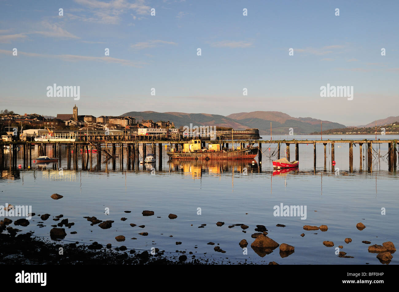 Pontile in disuso e la città di Gourock attraverso Gourock Bay Foto Stock