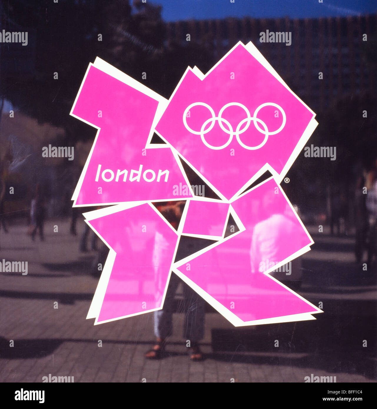 Il 2012 logo olimpico con riflessioni di persone sul piazzale presso la stazione di Stratford, East London, England Regno Unito KATHY DEWITT Foto Stock