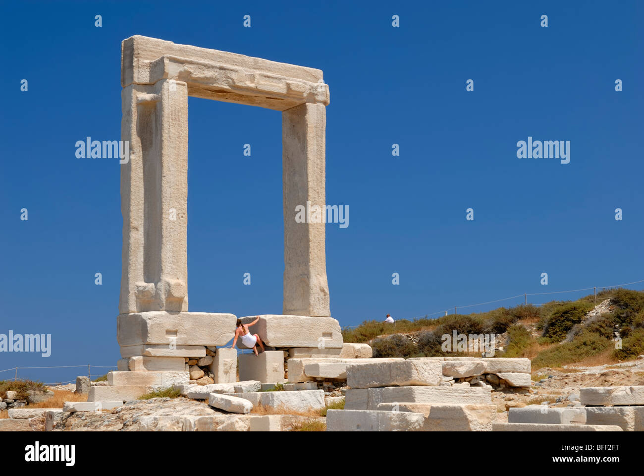 Il marmo enorme cancello, il Portara, cattura il tuo occhio non appena si arriva a Naxos. Un turista è disperatamente tentando di scalare... Foto Stock