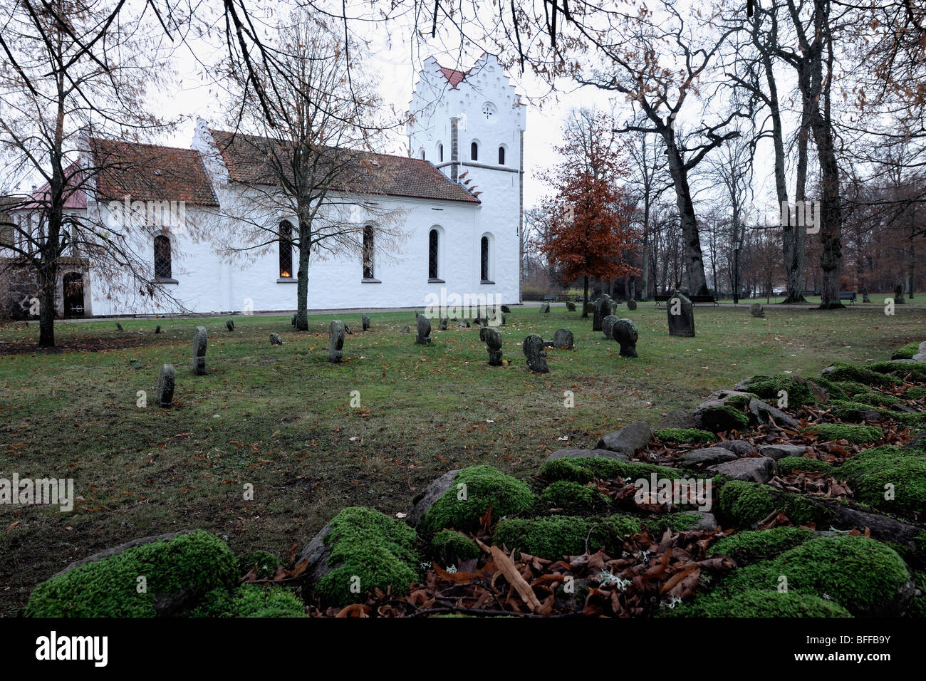 Un vecchio bianco chiesa romana con moss-coperto le lapidi. Foto Stock