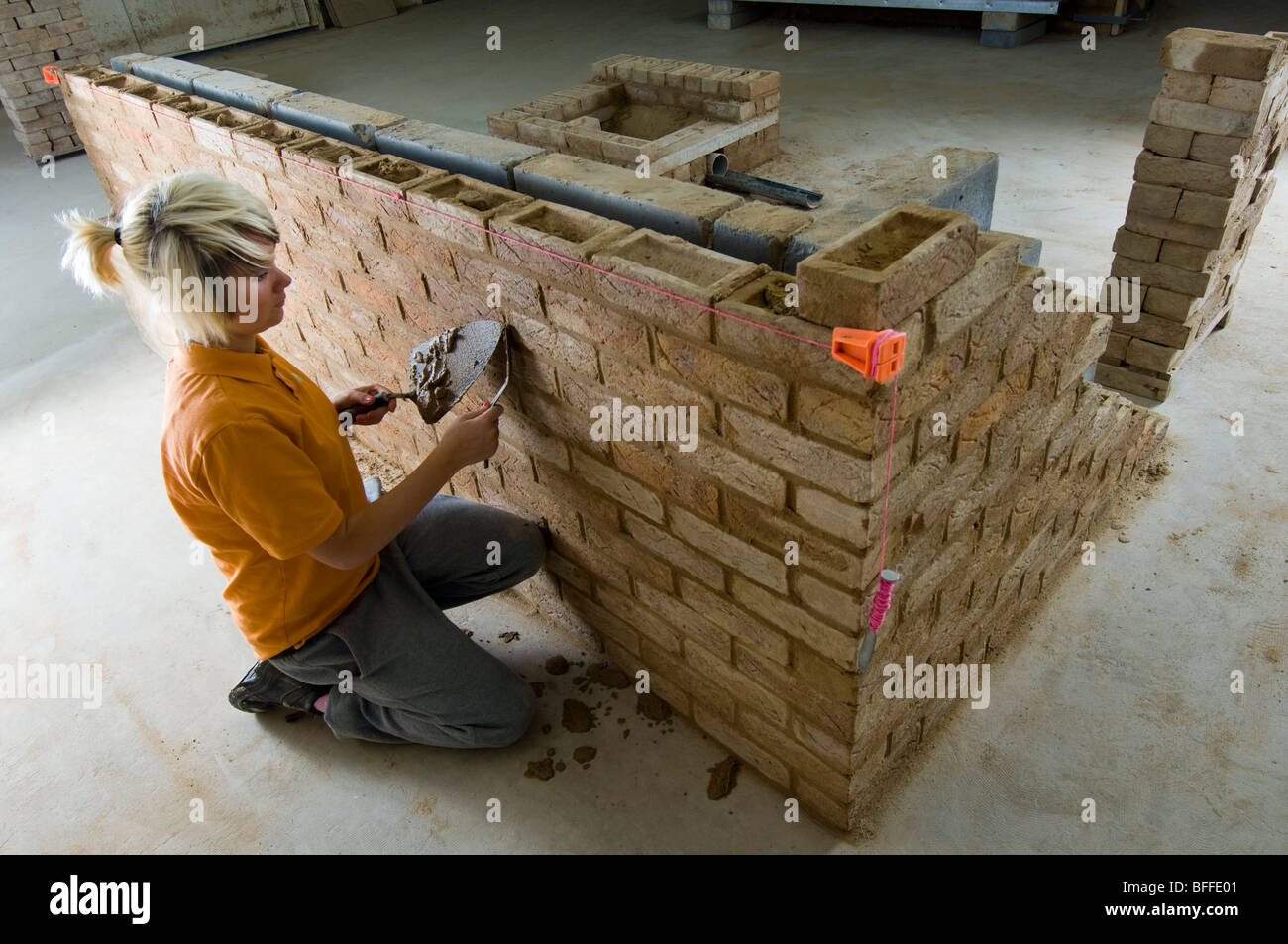 Una studentessa di apprendimento muratura pratico a 'City College Brighton' Foto Stock
