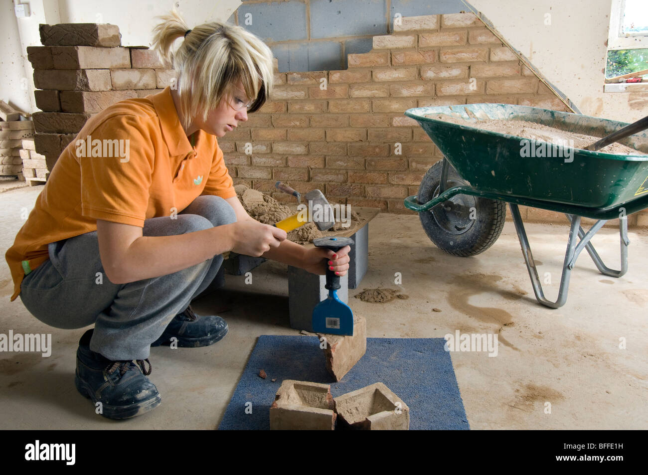 Una studentessa di apprendimento muratura pratico al City College Brighton Foto Stock