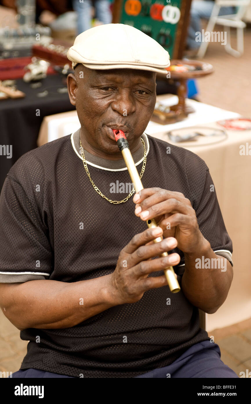 L'uomo gioca un africano flauto o flauto. Ellis Park Street Market. Durban, Sud Africa Foto Stock