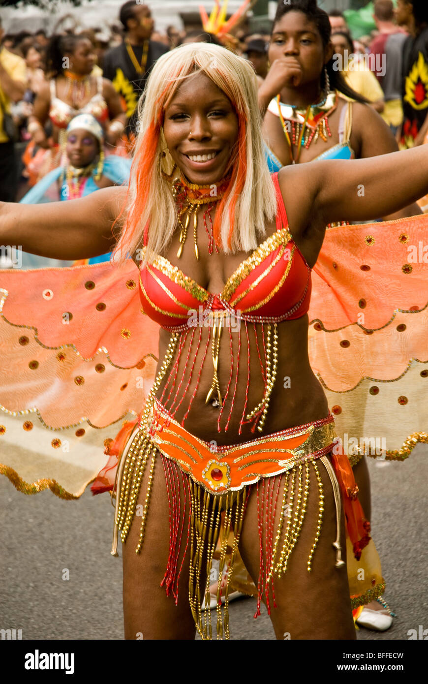 Scarsamente vestito donna che indossa un costume con fiocchi al carnevale di Notting Hill Foto Stock