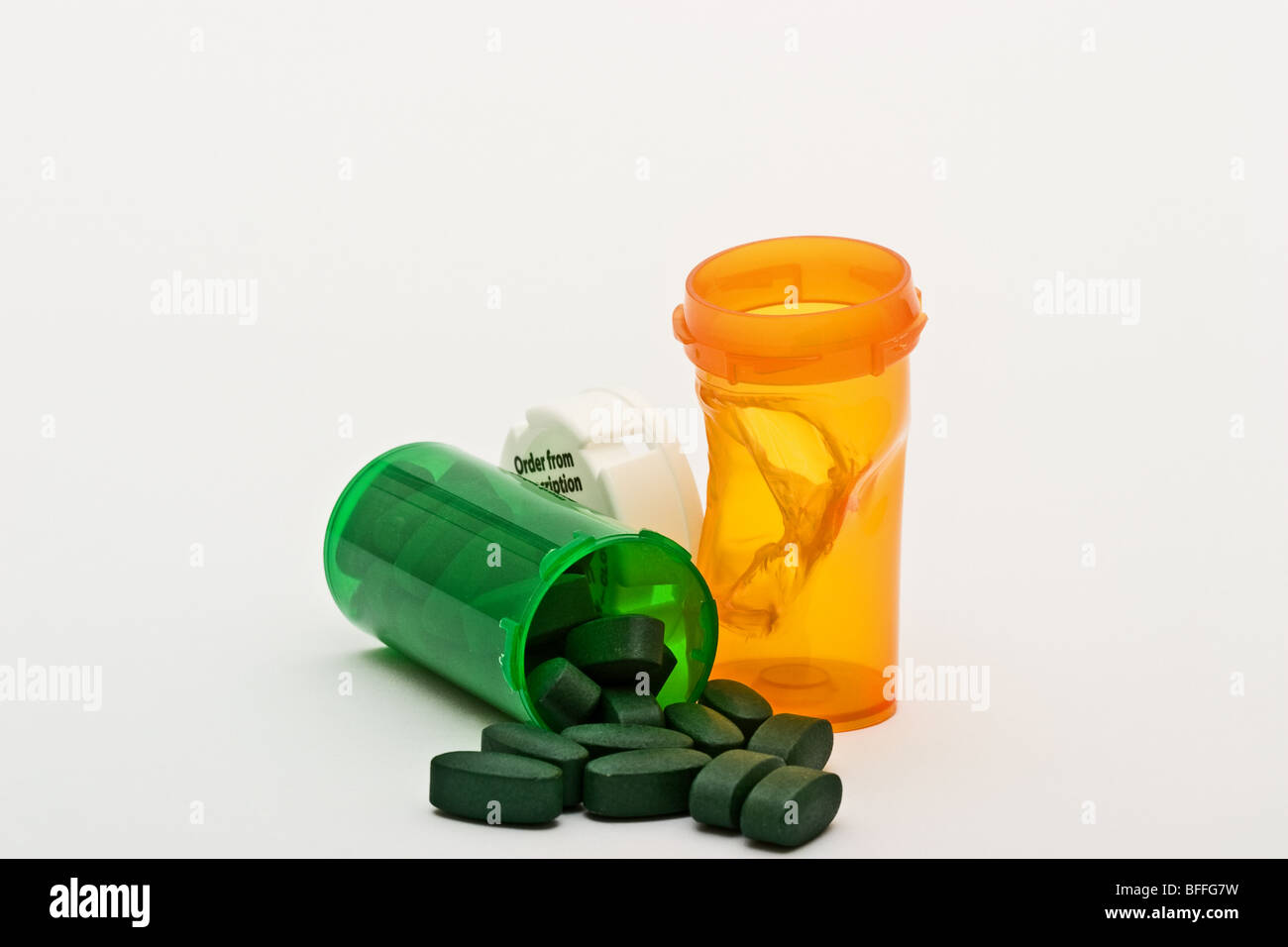 La plastica fusa bottiglia di prescrizione accanto alla capsula di chiusura in plastica bianca con una prescrizione verde bottiglia rovesciato con le pillole di verde Foto Stock