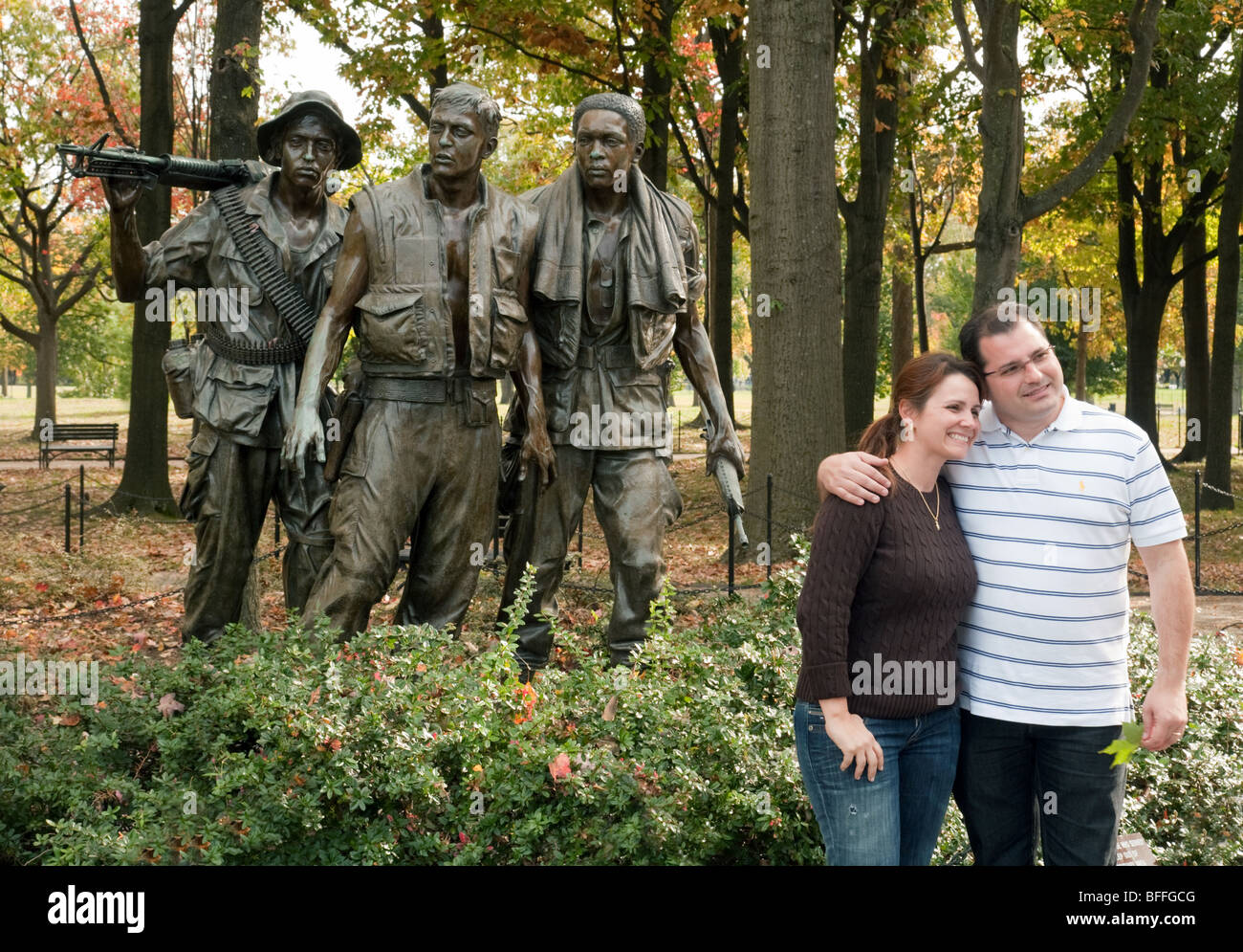 Un giovane pongono di fronte alla statua di tre soldati,i veterani del Vietnam War Memorial, Washington DC, Stati Uniti d'America Foto Stock