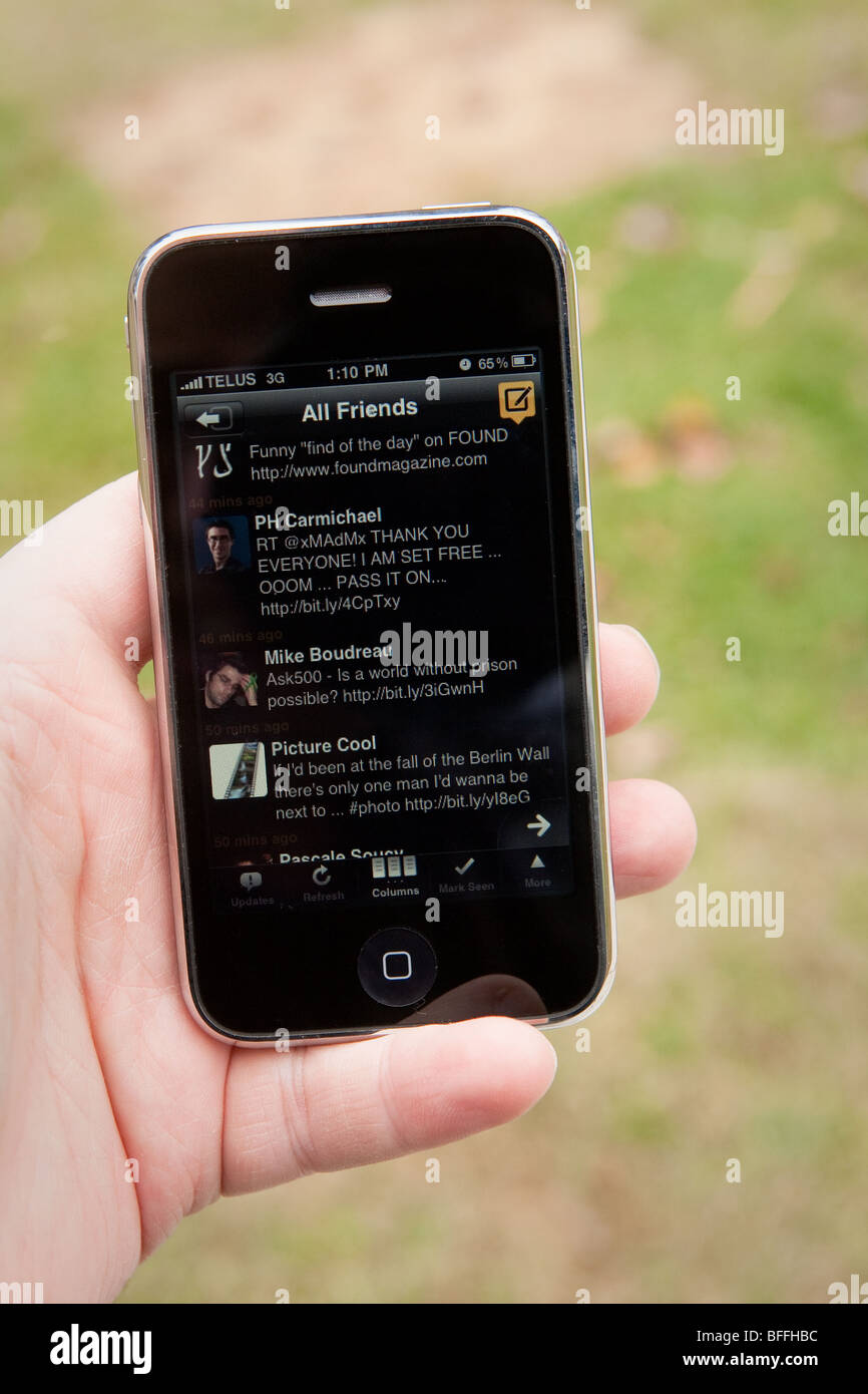 Un uomo utilizzare l' TweetDeck Twitter applicazione su un Apple iPhone. Foto Stock