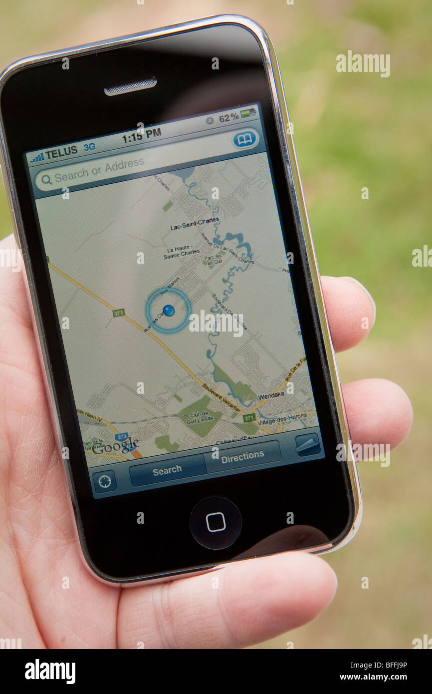 Un uomo di utilizzare l'applicazione di mappe su un Apple iPhone. Foto Stock