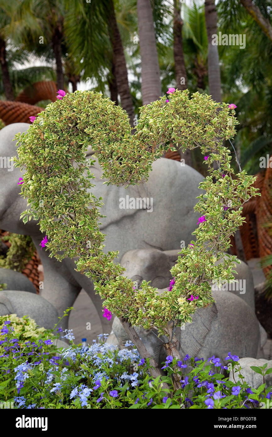 Scultura di elefante e a forma di cuore ad addestrati fronde fiorite a Suan Nong Nooch o NongNooch Tropical Botanical Garden Resort, Pattaya, Thailandia Foto Stock