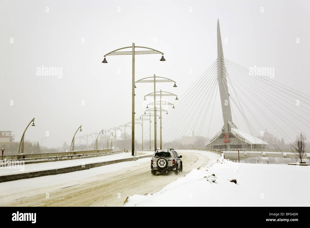 Jeep guidare oltre l'Esplanade Riel ponte in downtown Winnipeg, su un blustery, freddo giorno d'inverno. Winnipeg, Manitoba, Canada. Foto Stock