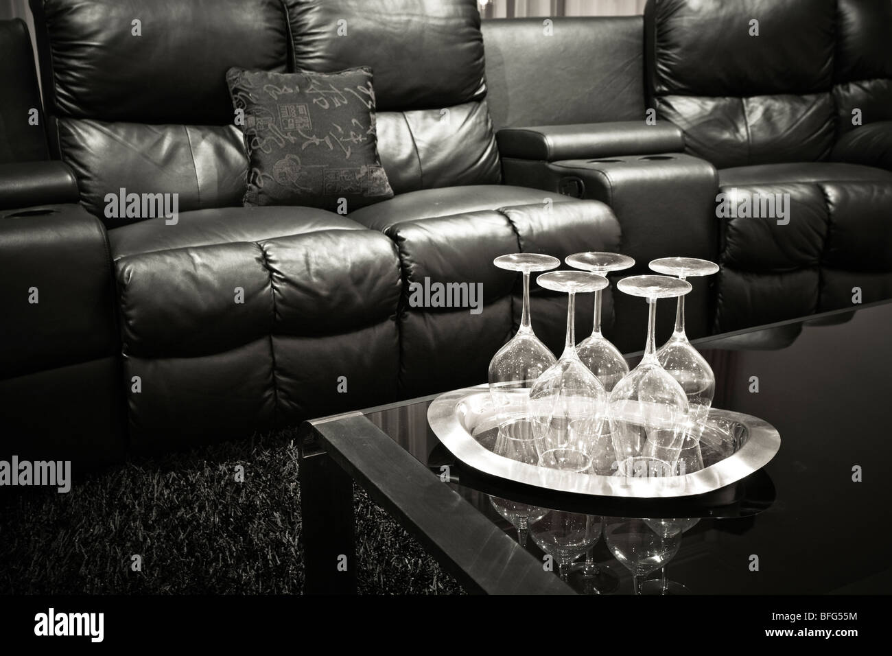 Executive nero home theatre sedie in pelle con bicchieri di vino sul vassoio sulla tavola nera Foto Stock