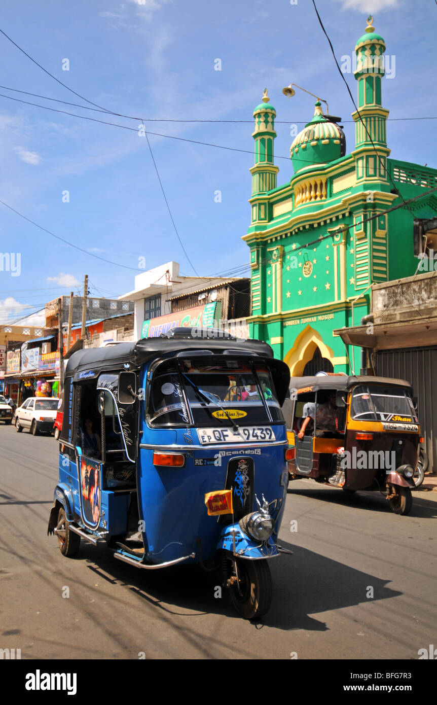 Porto di Trincomalee città nel nord-est dello Sri Lanka, via scena mostrando tuk tuks e una moschea, Trinco, Sri Lanka Foto Stock