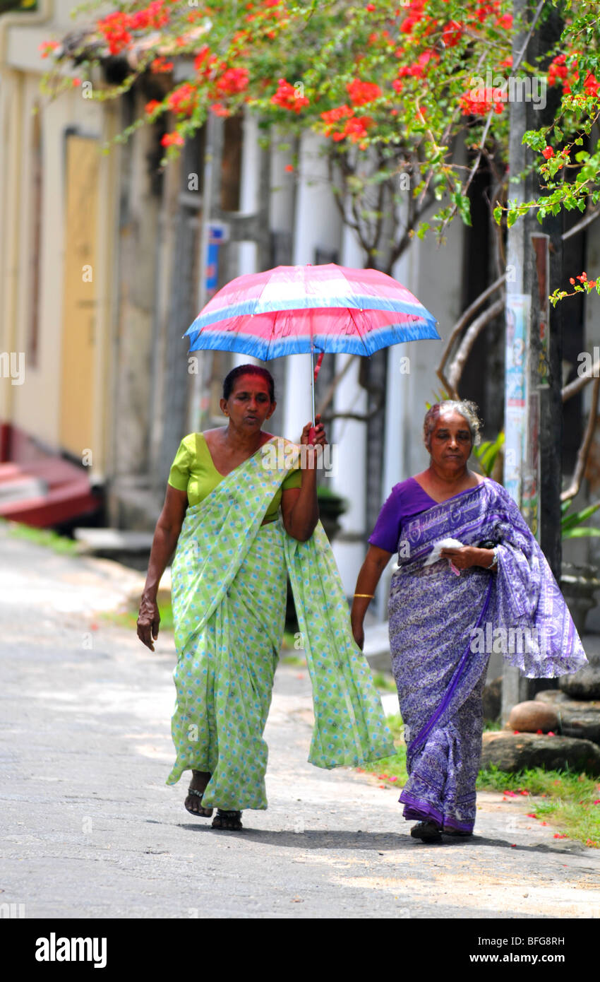 Sri Lanka, donne, camminando con ombrellone indossando saris, Sri Lanka Foto Stock