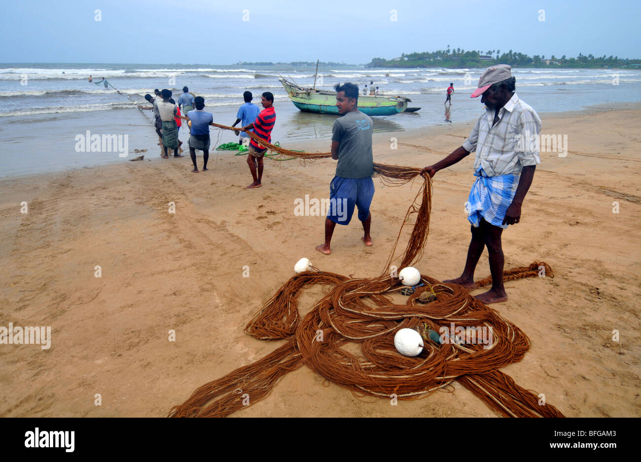 Tirare i pescatori nelle loro reti su una spiaggia vicino a Galle, Sri Lanka Foto Stock