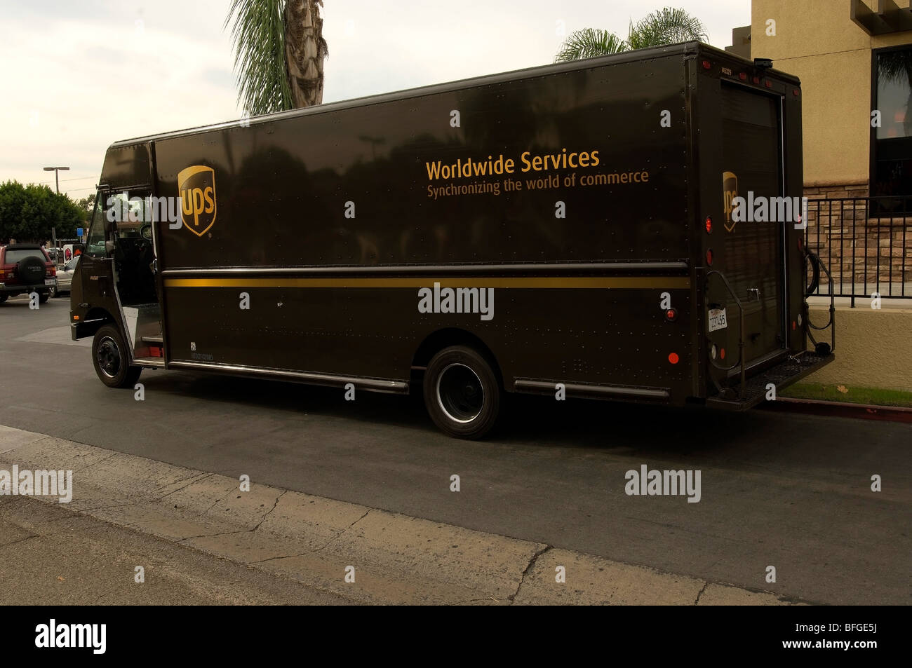 UPS Marrone carrello parcheggiato di fronte ad un'azienda che effettua un colpo di consegna. Foto Stock