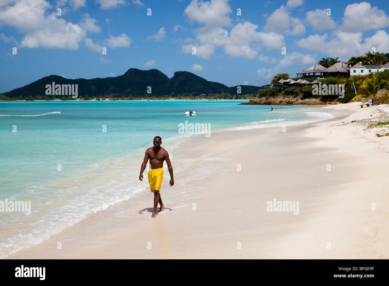Uomo nero a piedi lungo Ffryes bay, Antigua Foto Stock