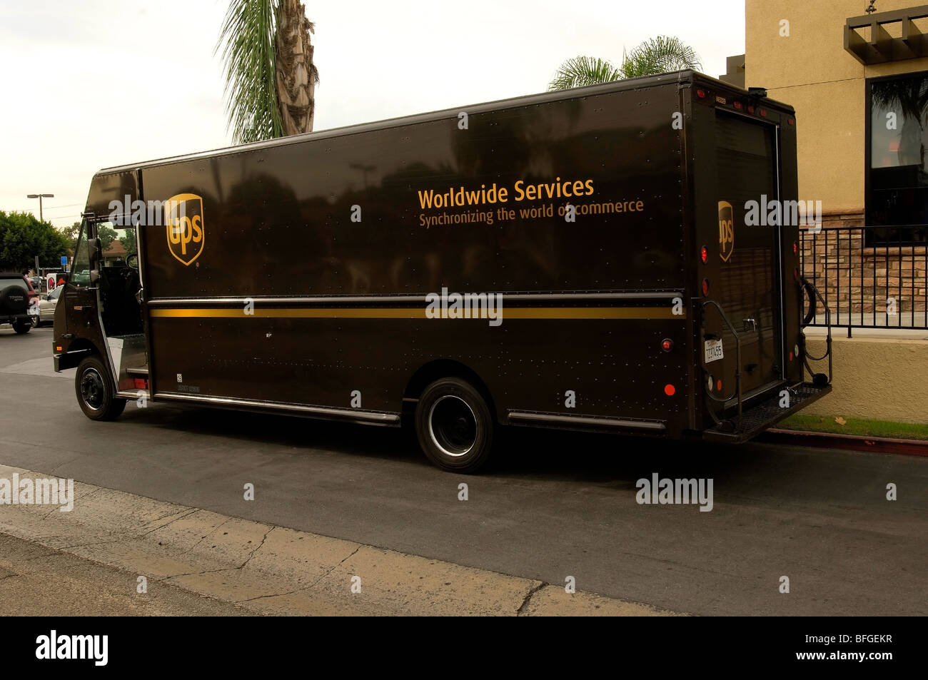 UPS Marrone carrello parcheggiato di fronte ad un'azienda che effettua un colpo di consegna. Foto Stock