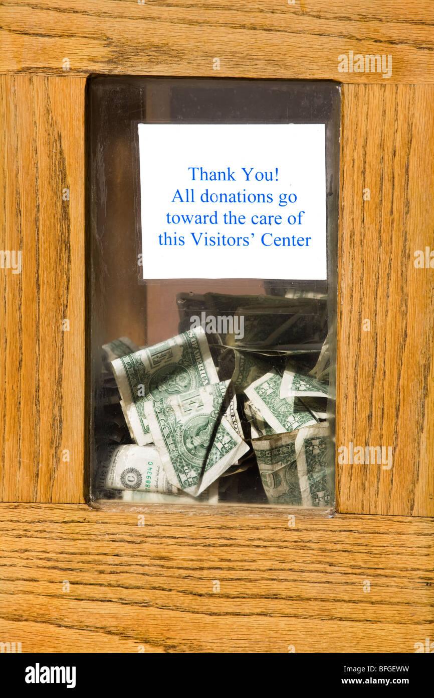 Una scatola di donazioni con le fatture del dollaro visibile dietro la finestra di vetro: tutte le donazioni andare verso la cura di questo centro visitatori. Foto Stock