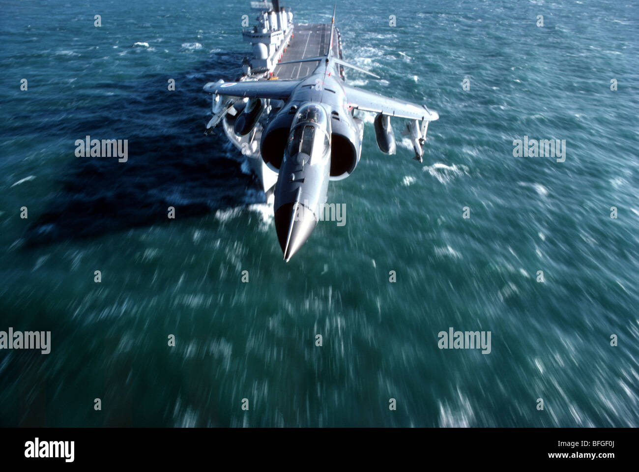 Royal Navy Sea Harrier con HMS invincibile in background Foto Stock