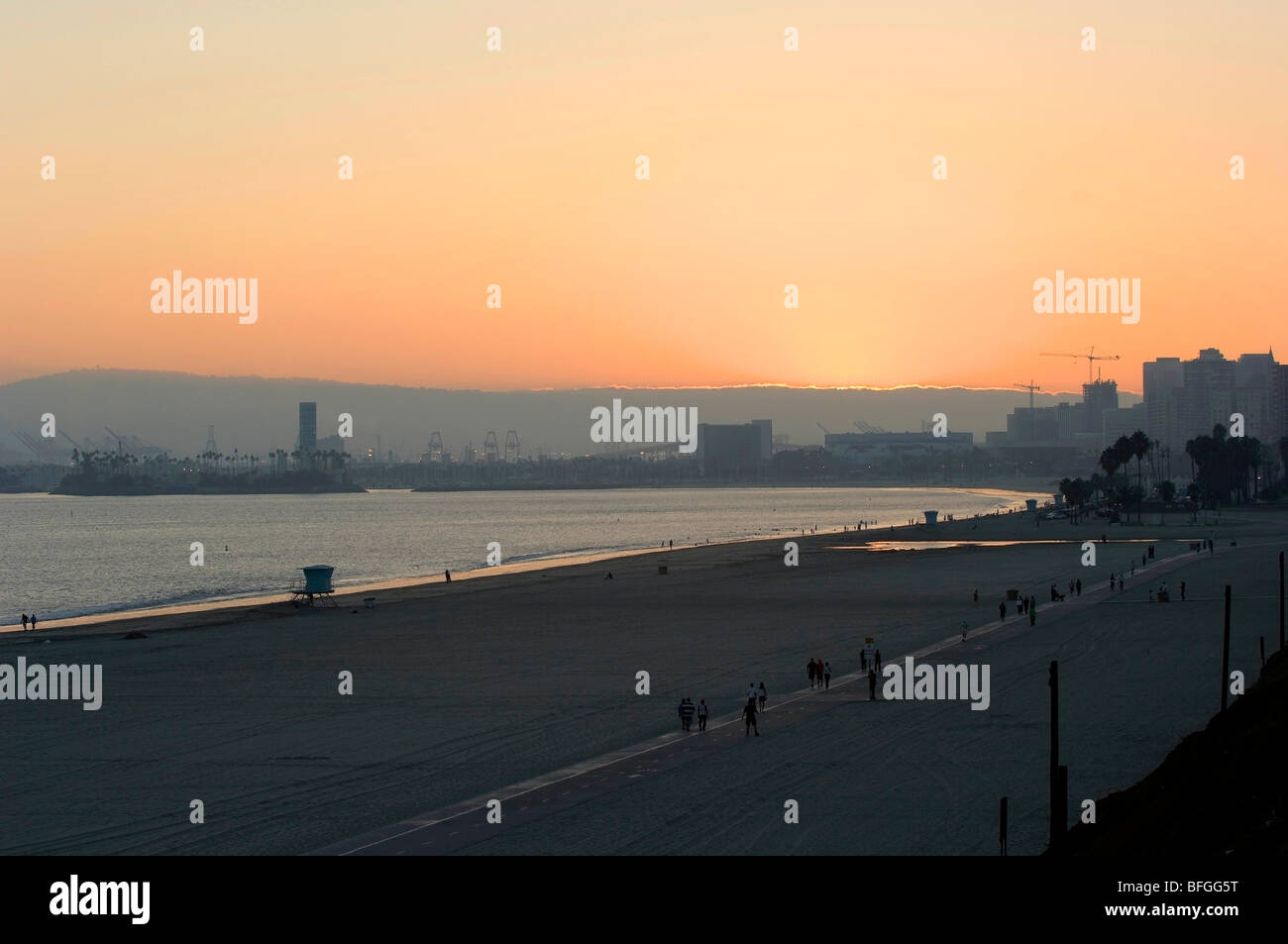 Lunga spiaggia di Porto e alla spiaggia al tramonto mettendo in evidenza il contrasto tra industria, spedizione, aziendali e di ricreazione. Foto Stock