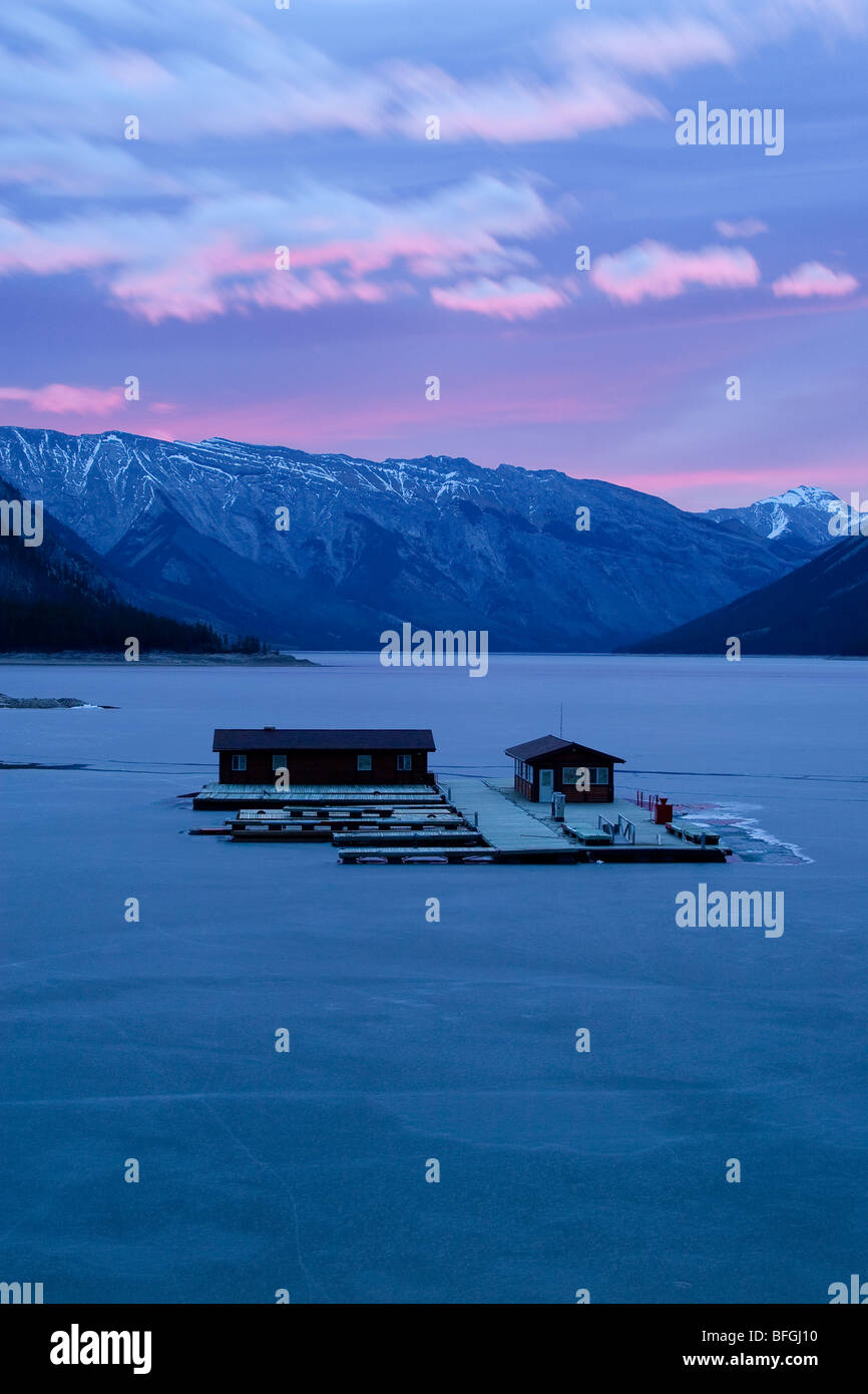 Pontile galleggiante sul lago ghiacciato Minnewanka all'alba, e il Parco Nazionale di Banff, Canada Foto Stock