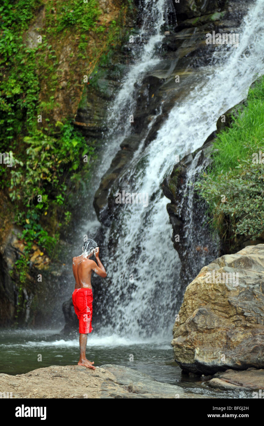 L'uomo lava in una cascata, Sri Lanka Foto Stock