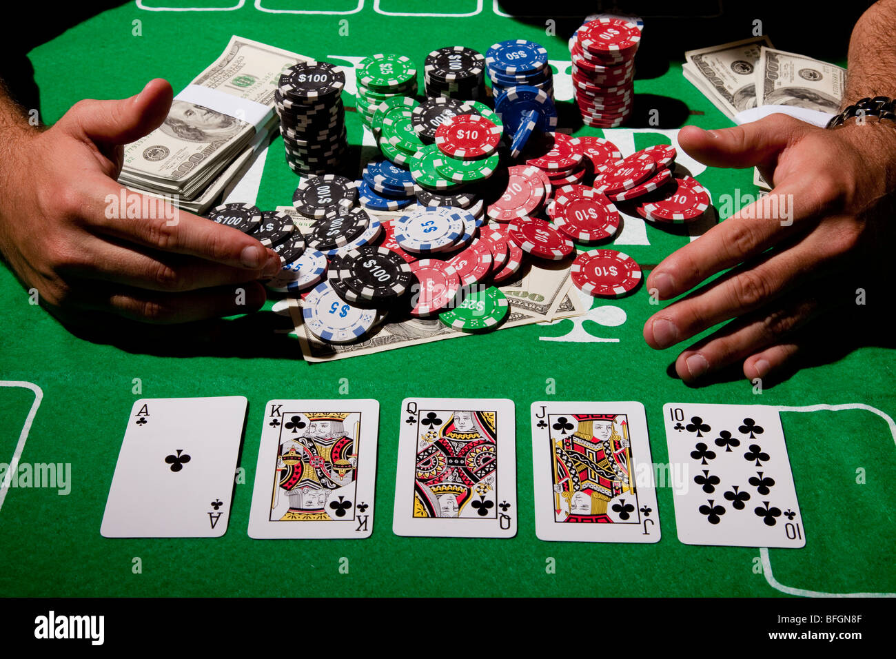 Un giovane maschio giocatore al tavolo da gioco e rastrelli nella sua vincita modello di rilascio disponibili Foto Stock