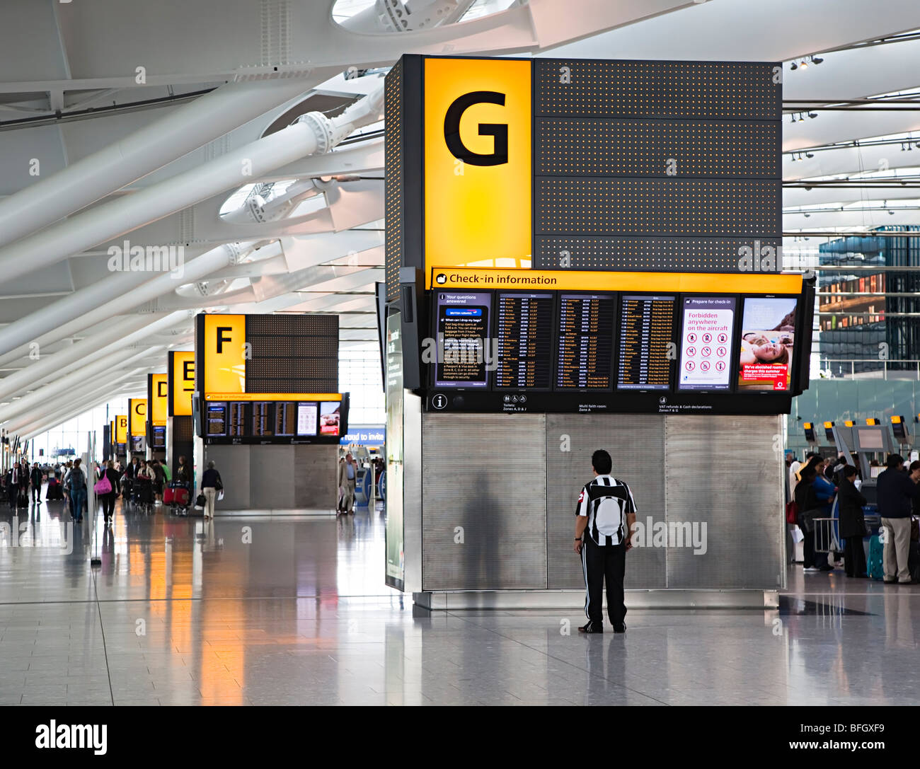 L'uomo controllo verificare nella schermata Informazioni sull'aeroporto internazionale di Heathrow Londra Inghilterra REGNO UNITO Foto Stock